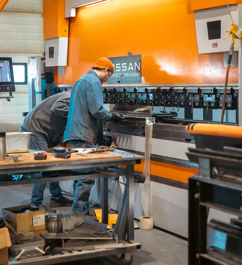 Two of the workers at Five Star Industries busy on a press brake.